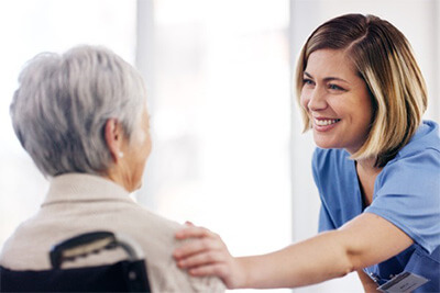 smiling nurse with senior woman at a retirement home