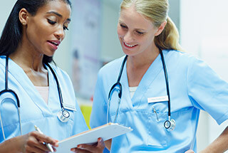 two female nurses discussing a chart