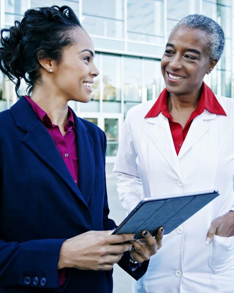 two nursing professionals looking at a tablet