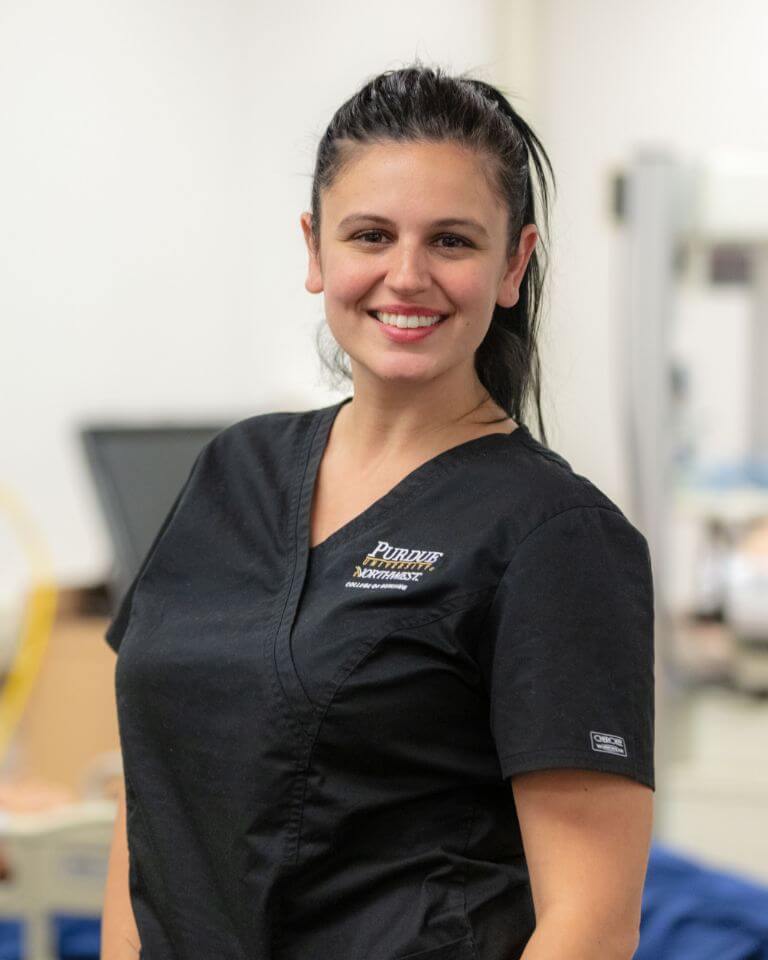 A smiling nurse wearing scrubs